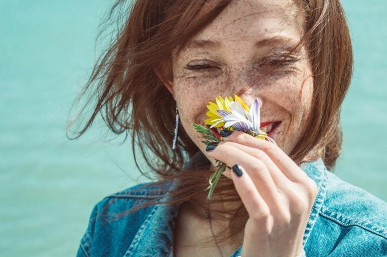 woman smelling flower, enjoying the small things