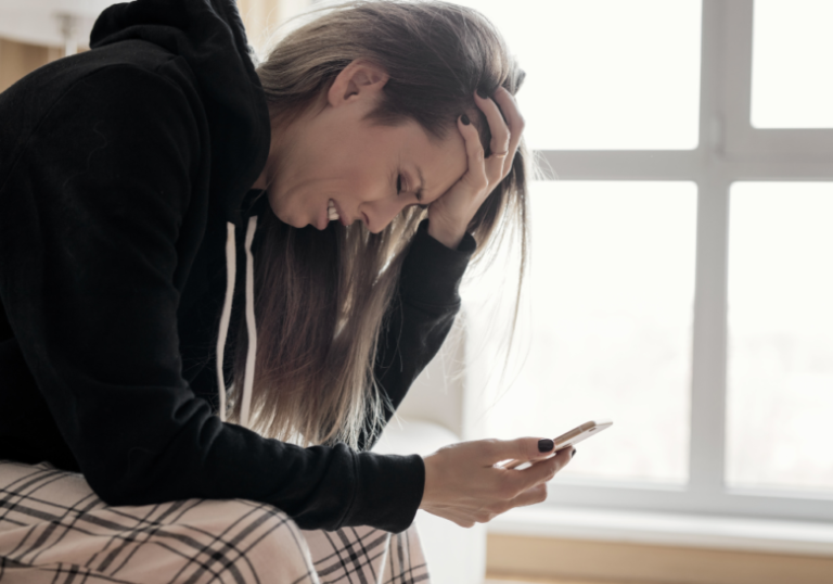 woman looking at her phone typing a text message to cheating boyfriend