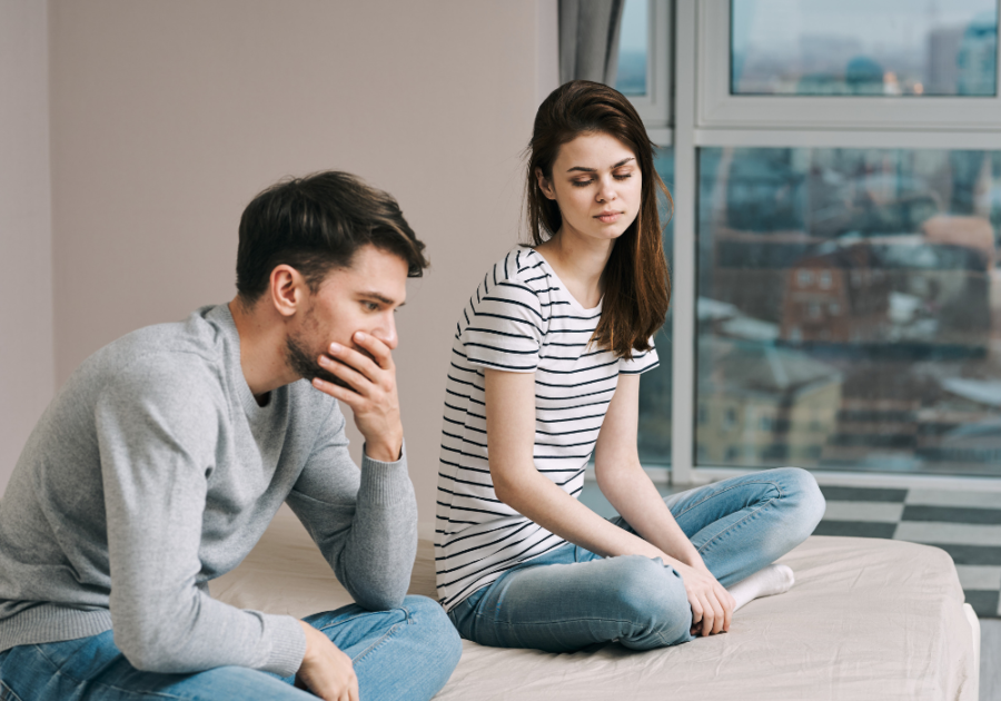 man and woman sitting on the bed signs a guy is pretending to be straight