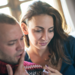 couple sitting on sofa looking at phone INFJ and INTJ Relationship