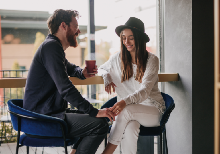 Couple having coffee holding hands Signs A Woman Is Sexually Attracted To You