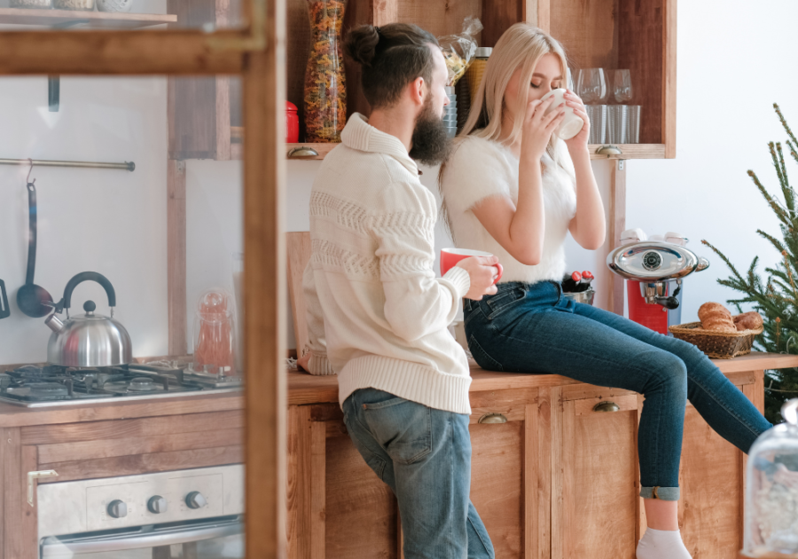 woman sitting on kitchen counter talking to man Ways a Cancer Man Tests You