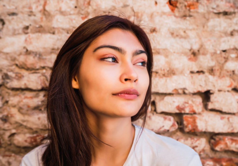 woman standing by brick wall looking away Weird Things Psychopaths Do