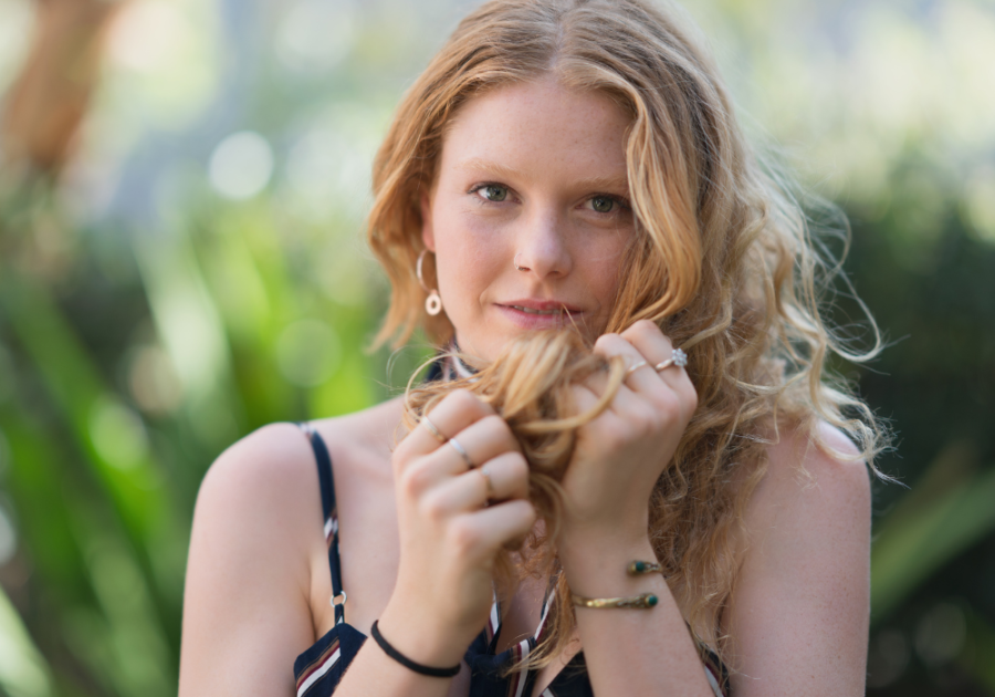 close up of woman holding her long hair what does it mean when she touches her hair when she sees you?