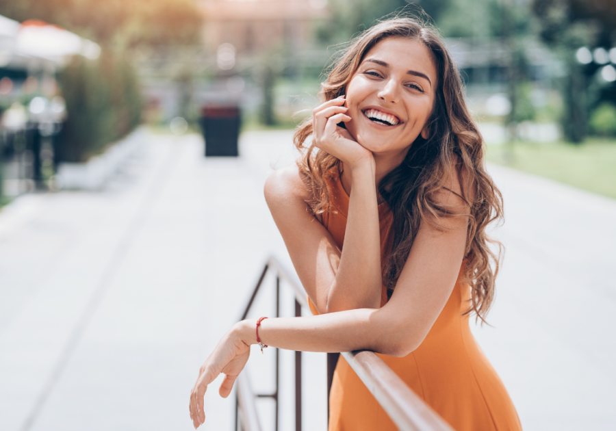 woman standing by walkway smiling Conventionally Attractive