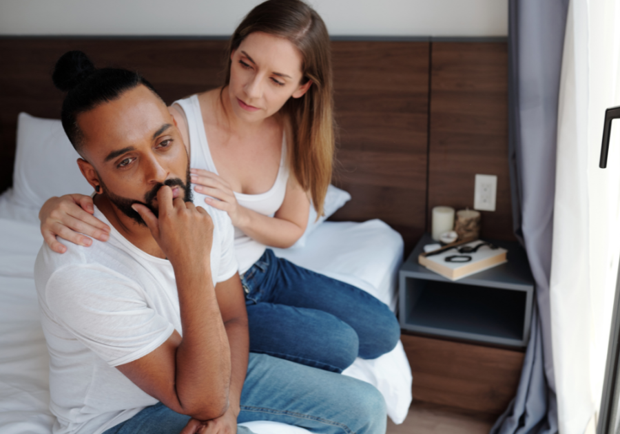 couple sitting on sofa woman touching man Reassurance in a Relationship