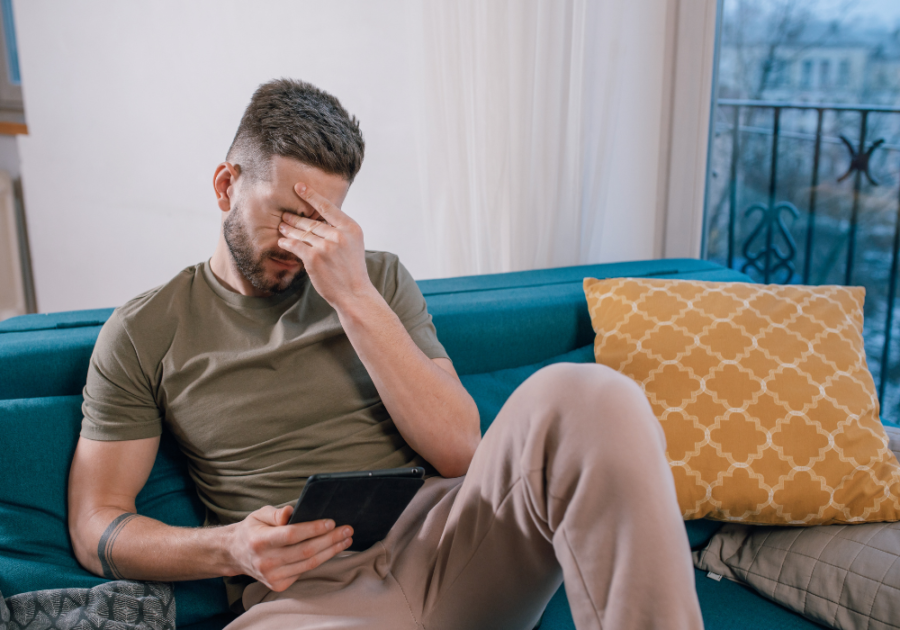 sad man sitting on sofa rubbing his eyes Someone You Love Hurts You