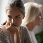 young woman sitting turned away from older woman i hate my mom