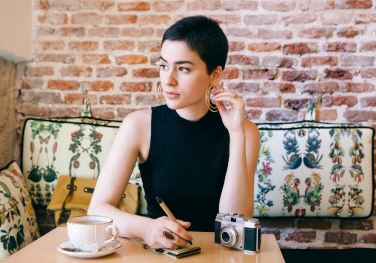 woman looking away sitting a table writing Psychological Effects of Being Single Too Long