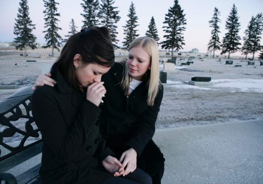 women sitting on bench one woman is crying Sympathy Messages for the Loss of a Mother