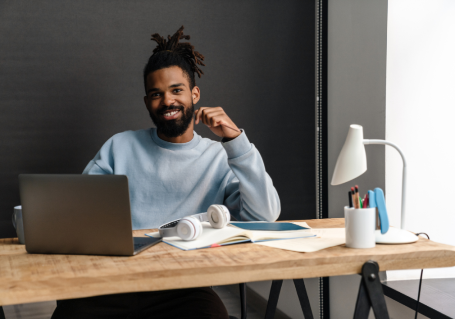 man smiling sitting at desk Signs of a Zeta Male