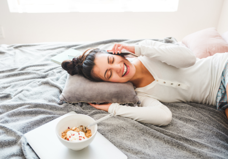 woman laying on bed talking on phone Long-Distance Relationship