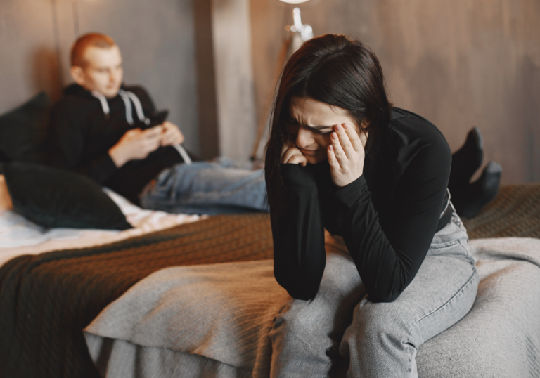 woman sitting on bed crying My Boyfriend Hates Me