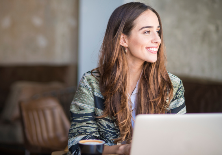 woman sitting in office at desk smiling Tinder Bios for Women