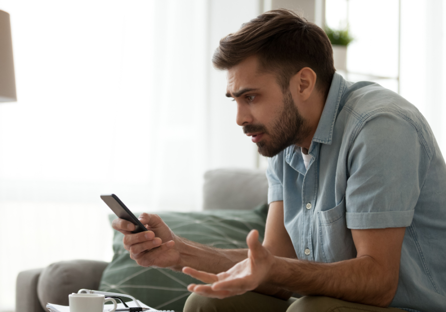 man frustrated looking at phone Why Do I Hate People