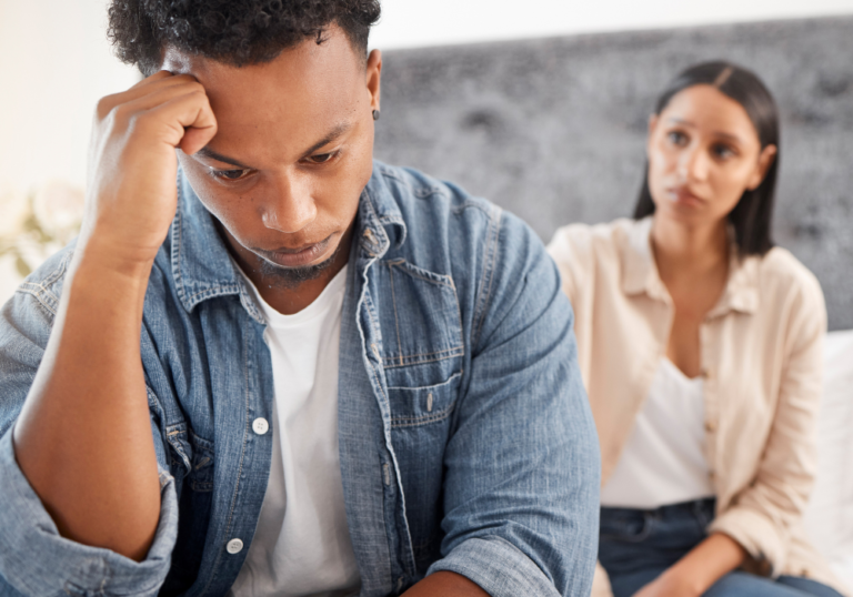 man sitting sad with woman trick questions to ask your girlfriend to see if she's cheating