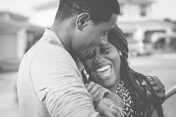 happy couple laughing how to be attractive