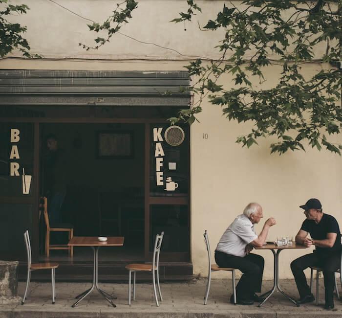 2 men at a cafe table talking empathic listening