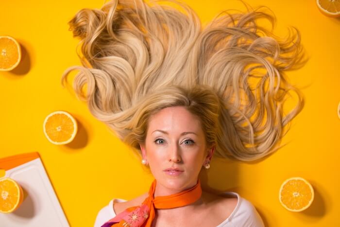 woman headshot beside oranges shallow person