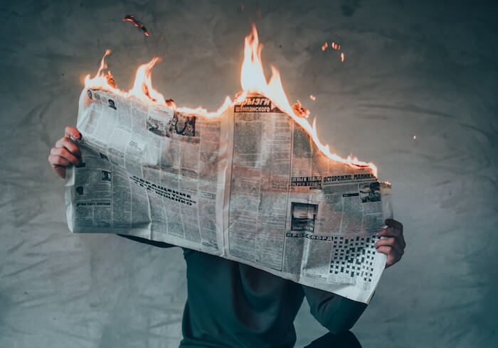 man sitting with newspaper on fire emotional maturity