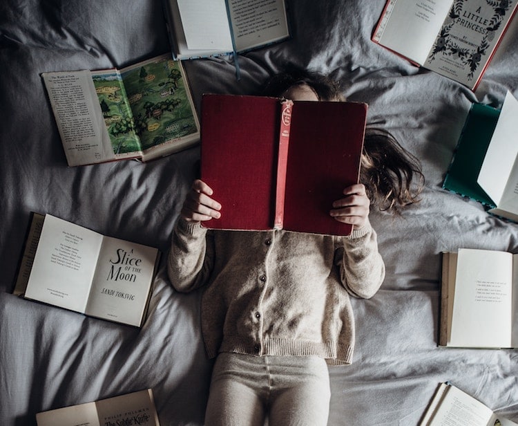 Girl reading books bed personal development goals