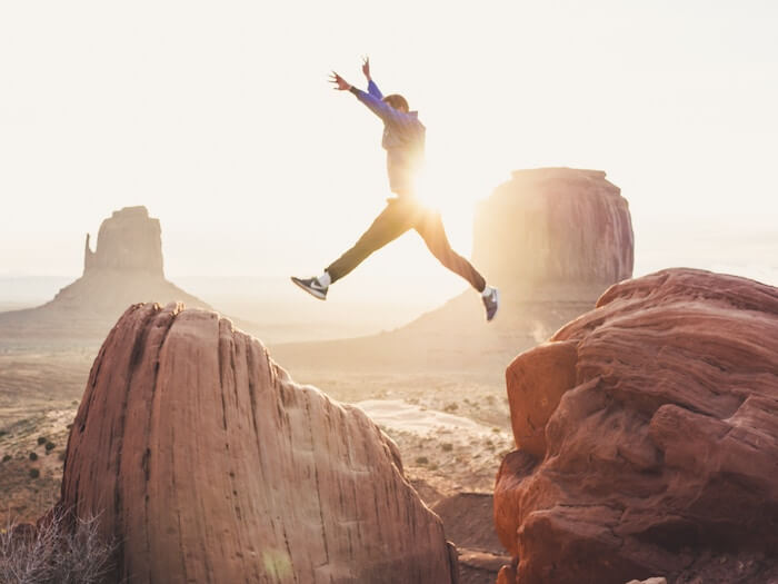 man jumping over rocks life goals