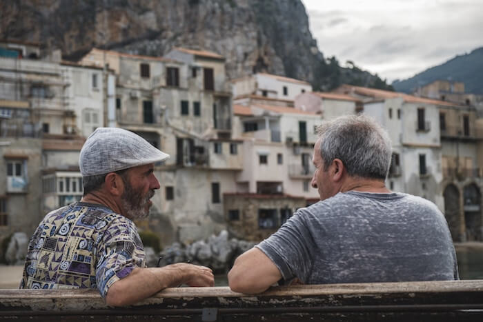 two men sitting on bench talking Questions to Ask Your Best Friend