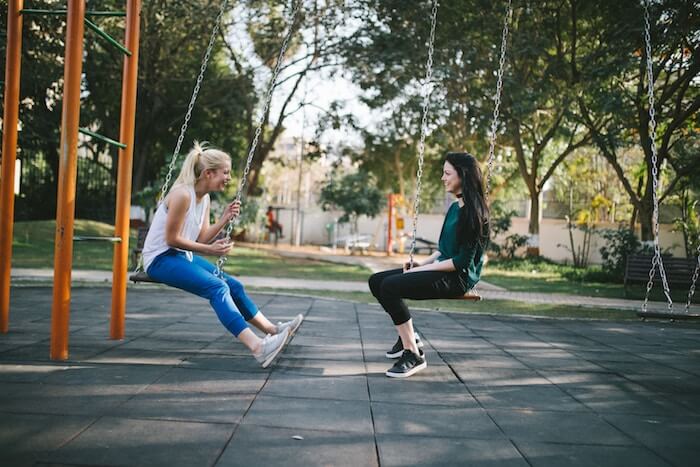 two women sitting in swings laughing best friend tag