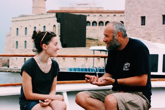 man and woman sitting talking by ocean How to Start a Conversation