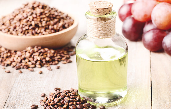 stack of grapeseeds and bottle of grapeseed oil