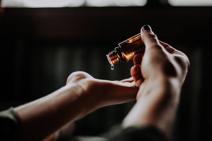 woman holding small bottle of oil benefits of grapeseed oil