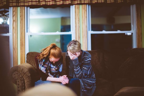 sad couple sitting on sofa, too much empathy