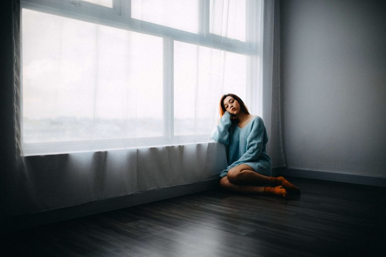 woman sitting in empty room alone Stop Overthinking After Being Cheated On