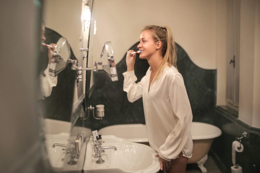 woman brushing teeth, travel toothbrush