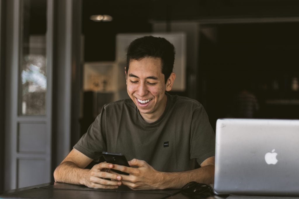 Man smiling while texting Thoughtful And Sweet Long Messages For Her