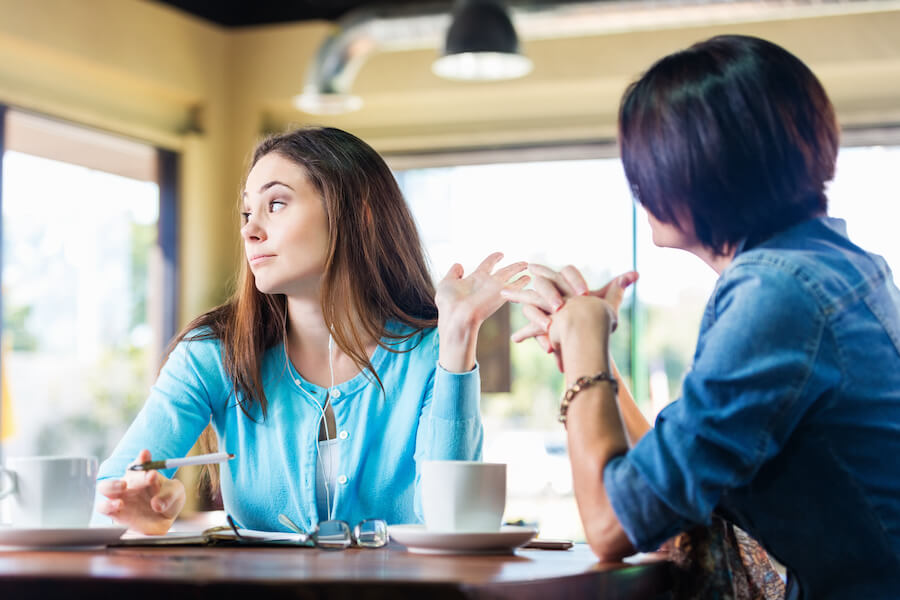 woman at table talking down to someone