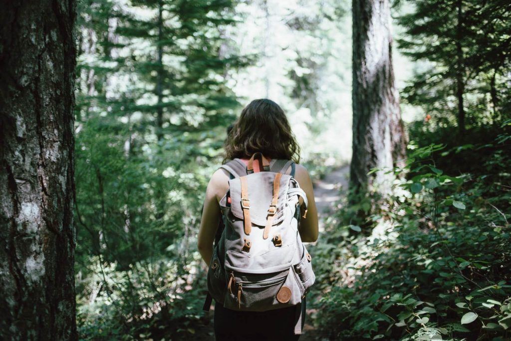 woman hiking in forest relaxing things to do