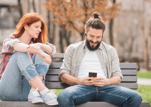 woman sitting beside man who is texting signs a woman is jealous of another woman