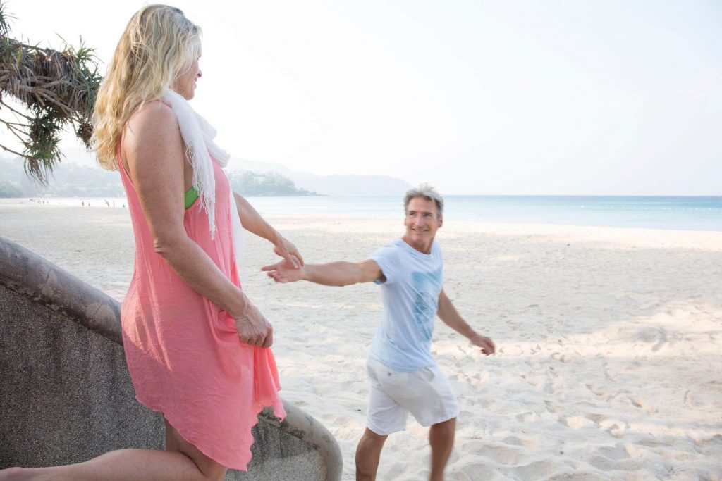 couple holding hands near ocean Signs of a Dominant Man 