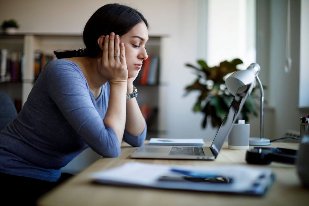 sad woman sitting at desk Signs You Have a Bad Attitude 