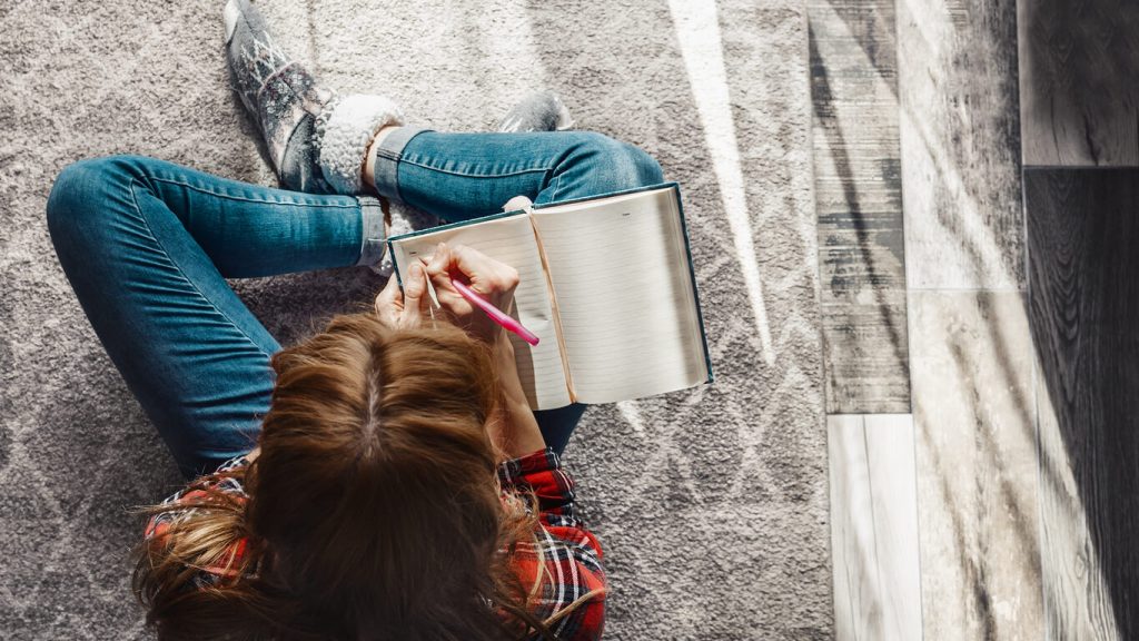 woman writing on her journal shifting affirmations