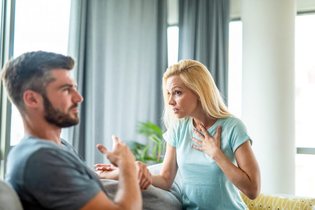 couple on sofa talking what to do when someone lies to you in a relationship