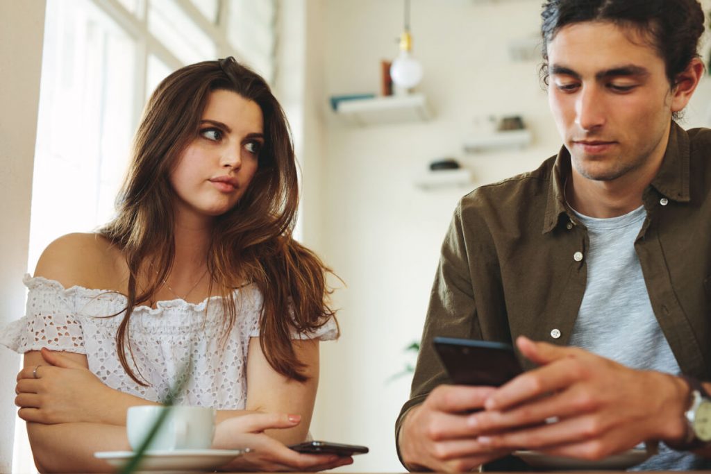 man ignoring woman looking at phone turn-offs for women