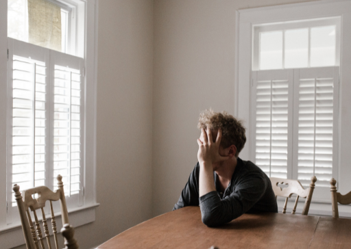 man in table holding face life is a mess