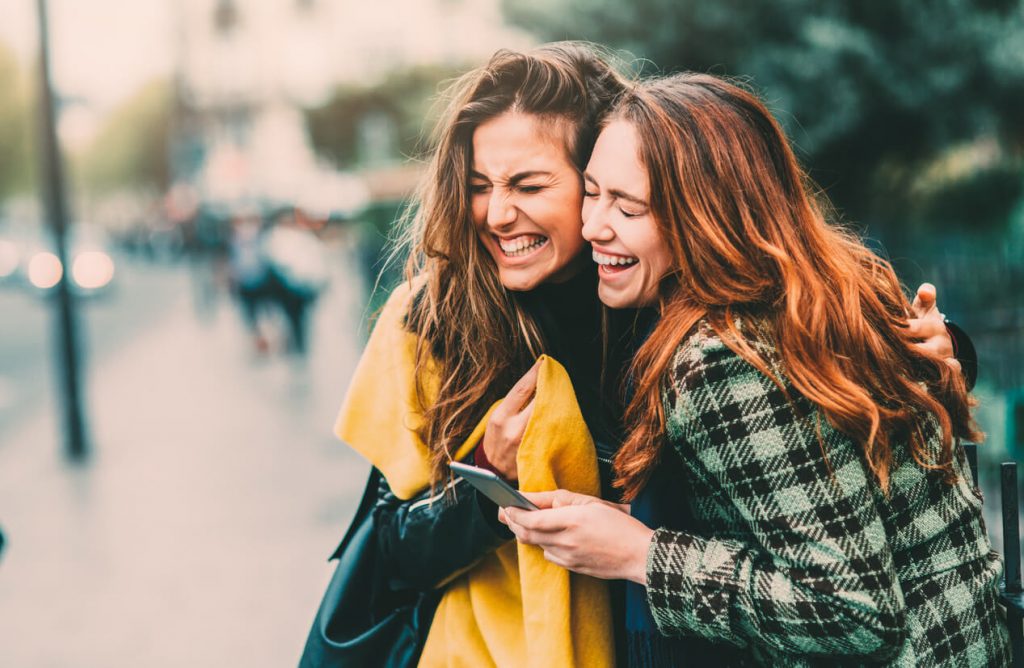 two women laughing hugging questions to ask your sister