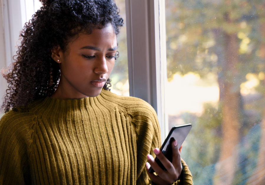 woman looking at phone how to get over insecurities after being cheated on