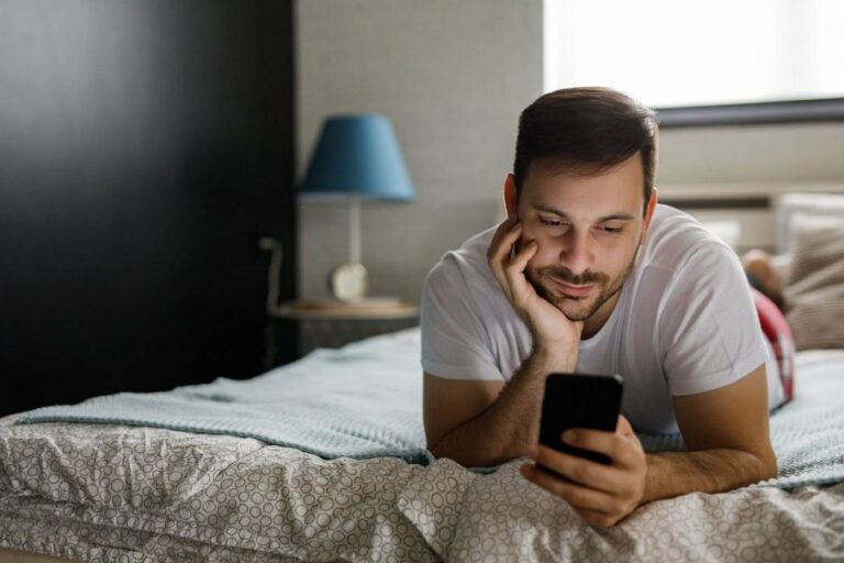 man looking at phone, words of encouragement for men