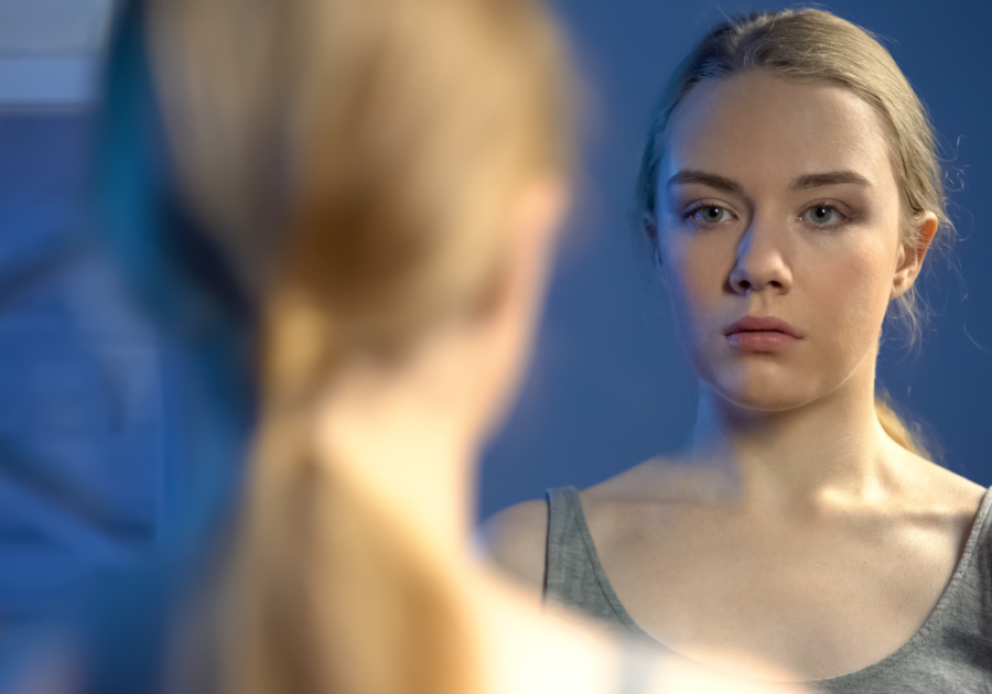 woman looking at her reflection feeling insecure how to be confident in a relationship