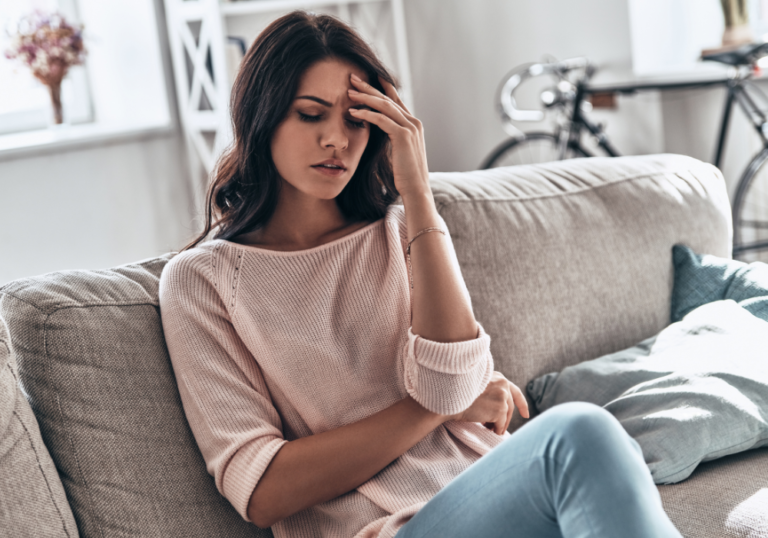 woman holding her head how to stop feeling guilty when you've done nothing wrong