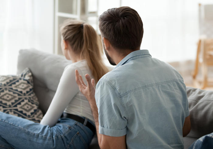 woman with back turned to man sitting on sofa my husband yells at me